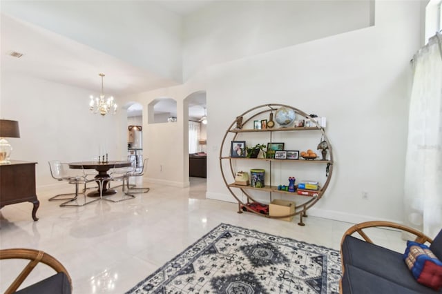 1120 Bluffs Cir, Dunedin, FL 34698 - living area with arched walkways, a chandelier, and a high ceiling