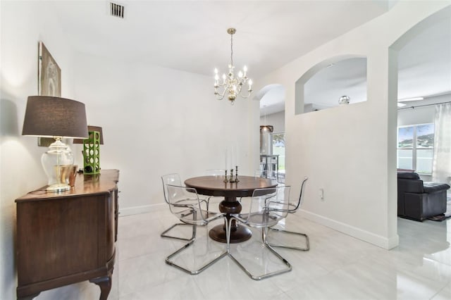 1120 Bluffs Cir, Dunedin, FL 34698 - dining area with arched walkways, a chandelier, and light tile patterned flooring