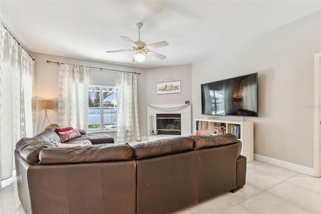1120 Bluffs Cir, Dunedin, FL 34698 - living area with ceiling fan, light tile patterned flooring, and a glass covered fireplace