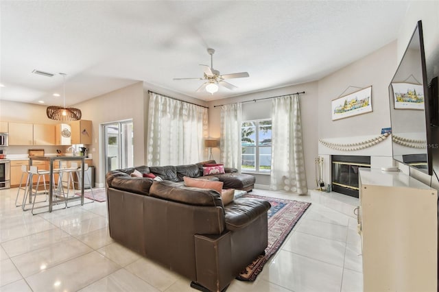 1120 Bluffs Cir, Dunedin, FL 34698 - living room featuring ceiling fan, a glass covered fireplace, light tile patterned floors, and recessed lighting