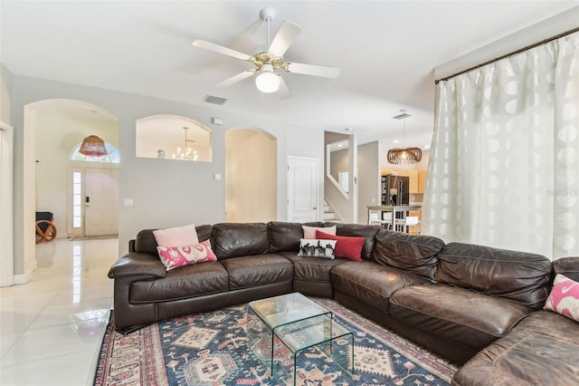 1120 Bluffs Cir, Dunedin, FL 34698 - living area featuring arched walkways, stairs, a ceiling fan, light tile patterned floors, and a chandelier