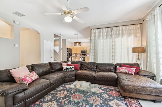 1120 Bluffs Cir, Dunedin, FL 34698 - living area with arched walkways, a ceiling fan, and stairs