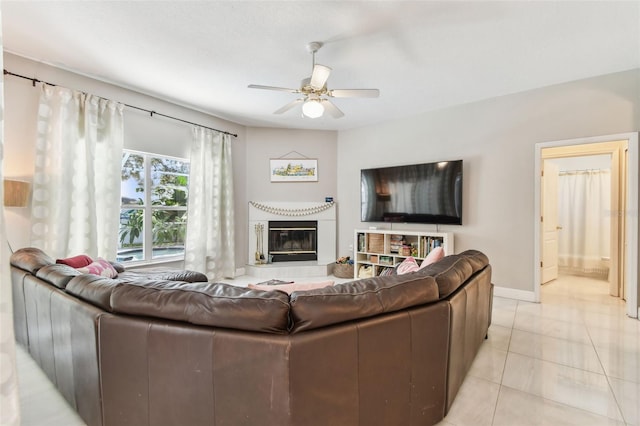 1120 Bluffs Cir, Dunedin, FL 34698 - living room with a ceiling fan, a glass covered fireplace, and light tile patterned flooring