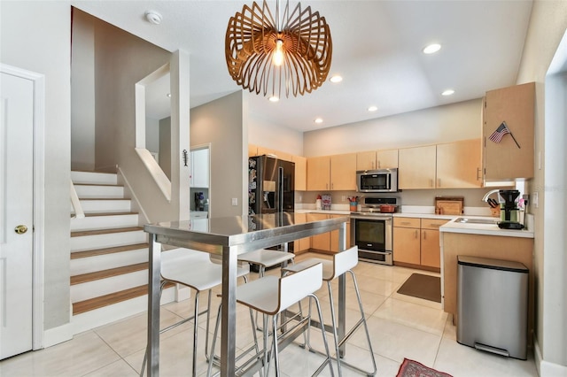 1120 Bluffs Cir, Dunedin, FL 34698 - kitchen featuring appliances with stainless steel finishes, light brown cabinetry, light tile patterned floors, light countertops, and recessed lighting