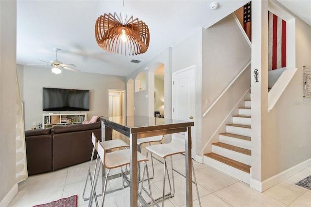 1120 Bluffs Cir, Dunedin, FL 34698 - dining room featuring arched walkways, light tile patterned floors, stairs, and ceiling fan