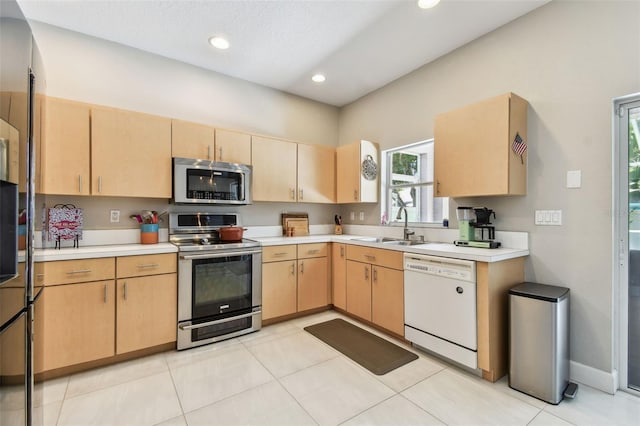 1120 Bluffs Cir, Dunedin, FL 34698 - kitchen with appliances with stainless steel finishes, light brown cabinetry, light countertops, recessed lighting, and light tile patterned flooring
