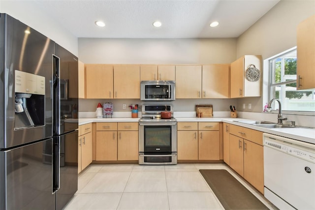 1120 Bluffs Cir, Dunedin, FL 34698 - kitchen featuring appliances with stainless steel finishes, light brown cabinets, light countertops, and recessed lighting
