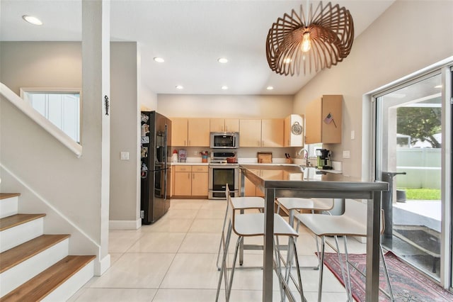 1120 Bluffs Cir, Dunedin, FL 34698 - kitchen featuring appliances with stainless steel finishes, light brown cabinetry, light tile patterned floors, recessed lighting, and light countertops