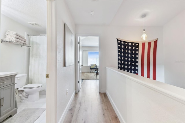 1120 Bluffs Cir, Dunedin, FL 34698 - hallway featuring light wood finished floors and an upstairs landing