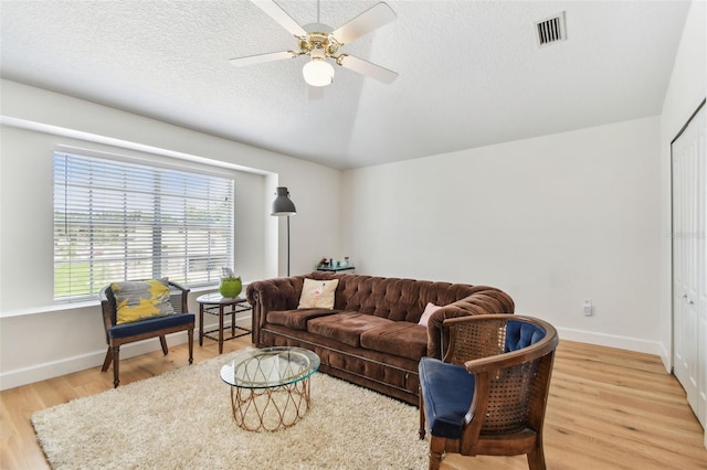 1120 Bluffs Cir, Dunedin, FL 34698 - living room with light wood finished floors, a ceiling fan, and a textured ceiling