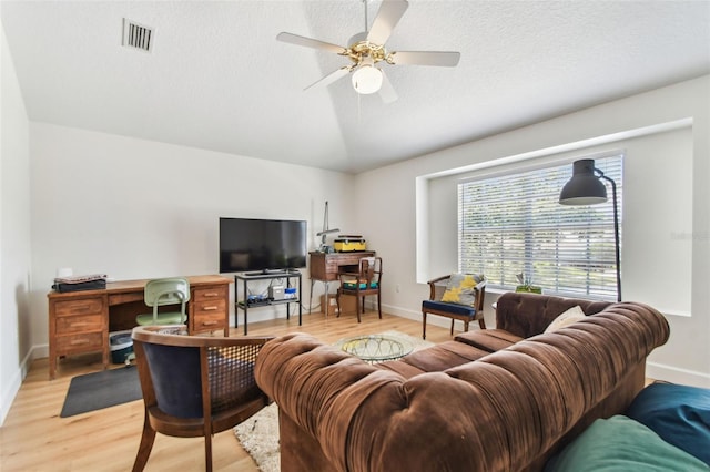 1120 Bluffs Cir, Dunedin, FL 34698 - living area with an office area, light wood-style floors, vaulted ceiling, ceiling fan, and a textured ceiling