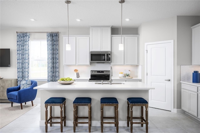 118 Venetian Palms Blvd, New Smyrna Beach, FL 32168 - kitchen featuring appliances with stainless steel finishes, a breakfast bar area, a textured ceiling, light countertops, and recessed lighting