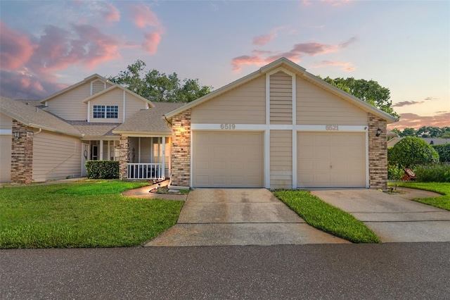 6519 Thicket Trl, New Port Richey, FL 34653 - view of front of home with concrete driveway, a lawn, brick siding, a garage, and roof with shingles