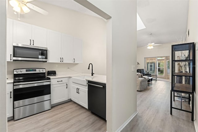 6519 Thicket Trl, New Port Richey, FL 34653 - kitchen featuring stainless steel appliances, ceiling fan, light wood-style flooring, and lofted ceiling