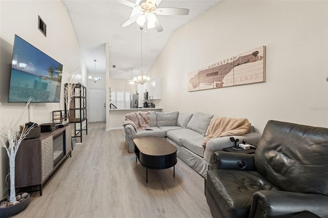 6519 Thicket Trl, New Port Richey, FL 34653 - living area featuring a chandelier, ceiling fan, light wood-type flooring, and high vaulted ceiling