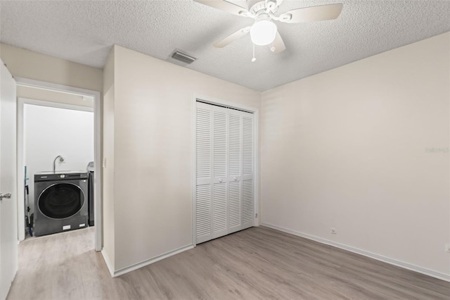6519 Thicket Trl, New Port Richey, FL 34653 - laundry area with washing machine and dryer, wood finished floors, ceiling fan, and a textured ceiling