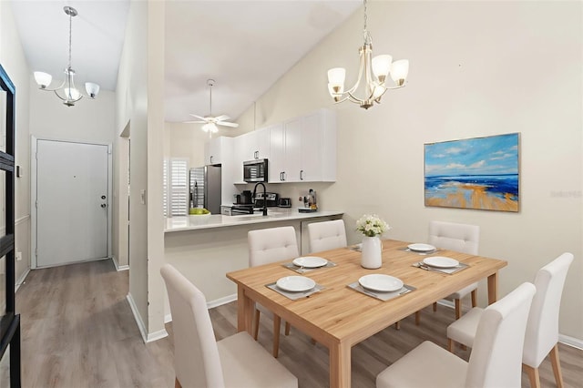 6519 Thicket Trl, New Port Richey, FL 34653 - dining space featuring a chandelier, light wood-type flooring, vaulted ceiling, and ceiling fan