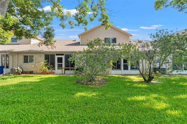 6519 Thicket Trl, New Port Richey, FL 34653 - rear view of house featuring a shingled roof, a sunroom, a lawn, and stucco siding
