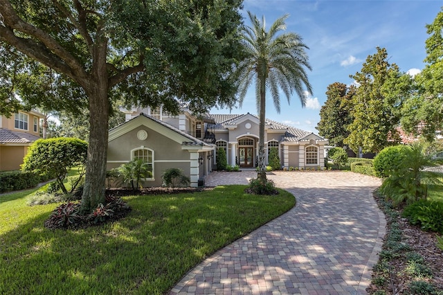 10508 Pontofino Cir, Trinity, FL 34655 - mediterranean / spanish house featuring stucco siding, decorative driveway, and a front lawn