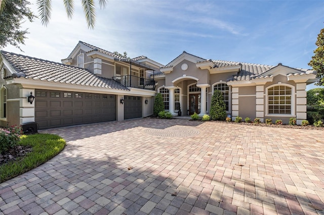10508 Pontofino Cir, Trinity, FL 34655 - mediterranean / spanish-style house with a balcony, decorative driveway, an attached garage, a tile roof, and stucco siding