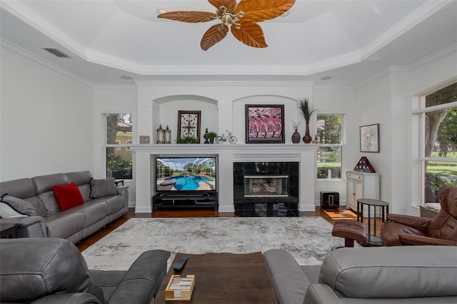 10508 Pontofino Cir, Trinity, FL 34655 - living room with a tray ceiling, wood finished floors, healthy amount of natural light, a tiled fireplace, and crown molding