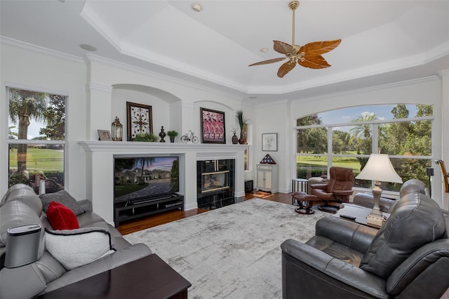 10508 Pontofino Cir, Trinity, FL 34655 - living area with plenty of natural light, a tiled fireplace, ceiling fan, wood finished floors, and ornamental molding