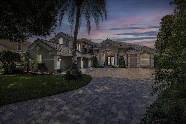 10508 Pontofino Cir, Trinity, FL 34655 - mediterranean / spanish-style home featuring a balcony, decorative driveway, french doors, stucco siding, and an attached garage