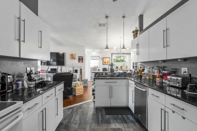 3539 Anniversary Ct, New Port Richey, FL 34653 - kitchen featuring stainless steel dishwasher, a peninsula, dark wood-style floors, white cabinetry, and range