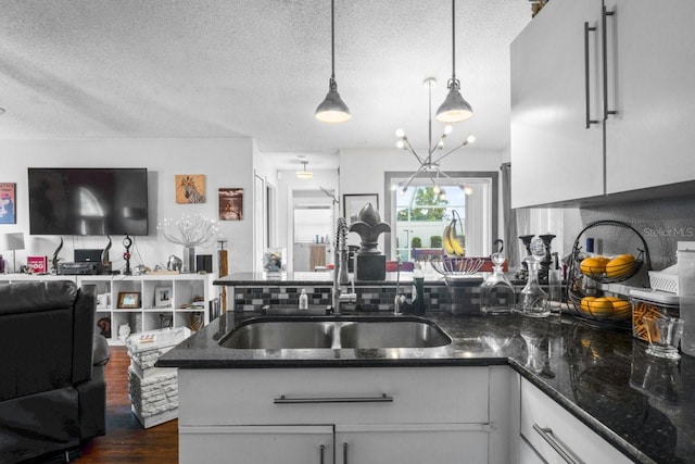3539 Anniversary Ct, New Port Richey, FL 34653 - kitchen featuring open floor plan, a textured ceiling, dark stone countertops, white cabinets, and a peninsula