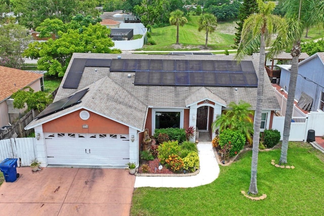 3539 Anniversary Ct, New Port Richey, FL 34653 - view of front of home with concrete driveway, an attached garage, a shingled roof, and solar panels