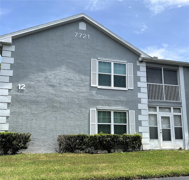 7721 Hillside Ct Unit 203, Hudson, FL 34667 - view of side of home featuring stucco siding and a yard