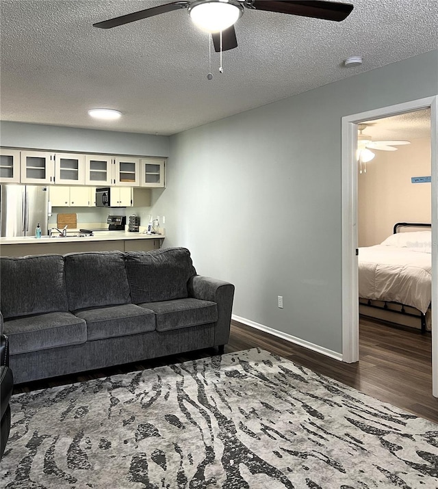 7721 Hillside Ct Unit 203, Hudson, FL 34667 - living area featuring ceiling fan, dark wood-type flooring, and a textured ceiling