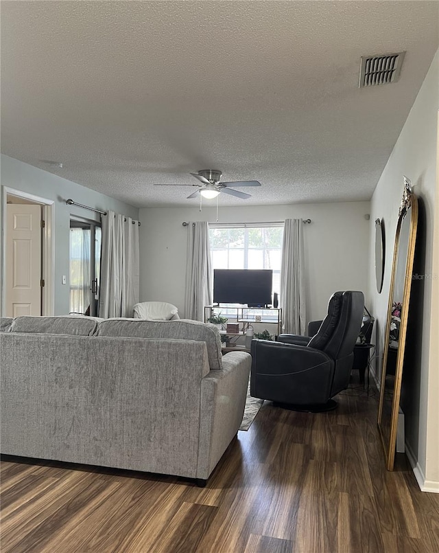 7721 Hillside Ct Unit 203, Hudson, FL 34667 - living room featuring a textured ceiling, dark wood finished floors, and a ceiling fan