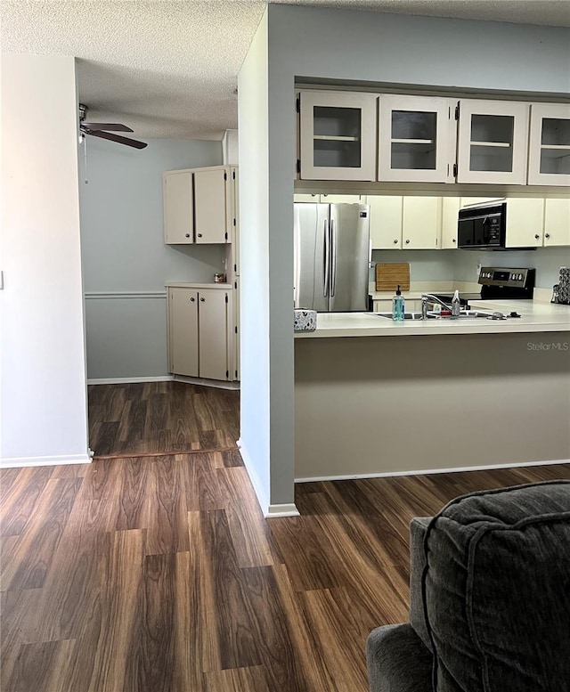 7721 Hillside Ct Unit 203, Hudson, FL 34667 - kitchen with stainless steel appliances, glass insert cabinets, a ceiling fan, dark wood finished floors, and light countertops