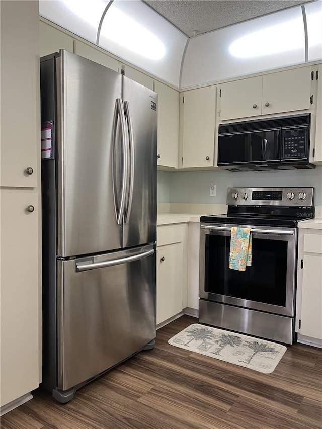7721 Hillside Ct Unit 203, Hudson, FL 34667 - kitchen with appliances with stainless steel finishes, light countertops, dark wood-style flooring, and white cabinets