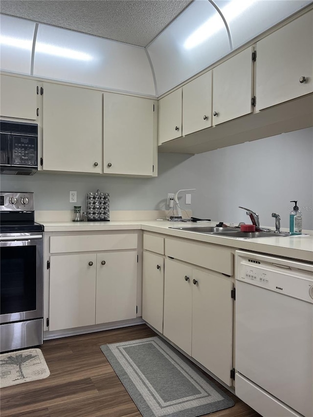 7721 Hillside Ct Unit 203, Hudson, FL 34667 - kitchen featuring black microwave, stainless steel range with electric stovetop, dishwasher, dark wood-style flooring, and light countertops