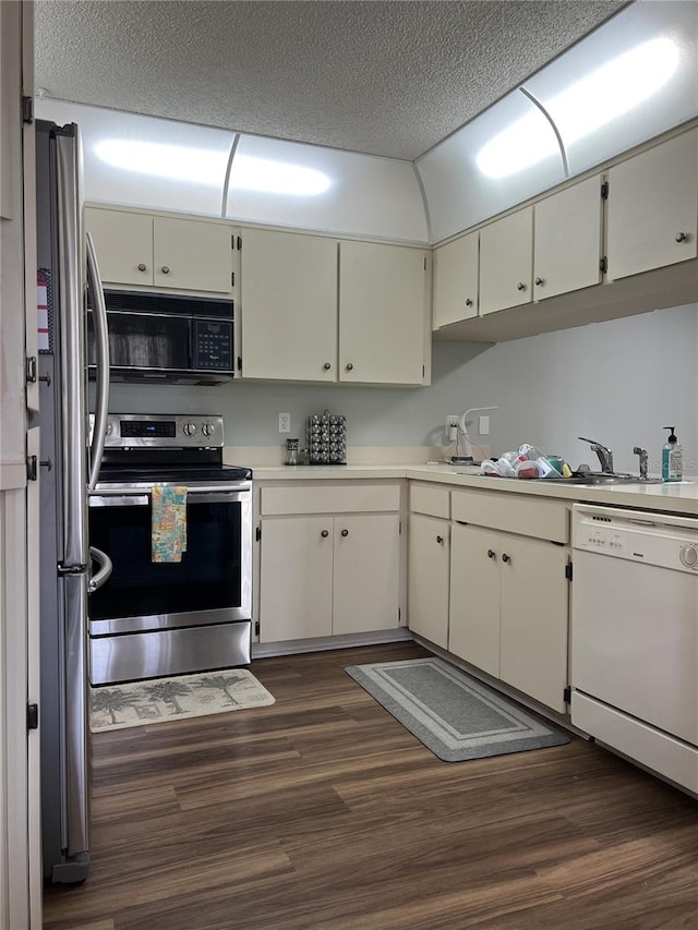 7721 Hillside Ct Unit 203, Hudson, FL 34667 - kitchen with appliances with stainless steel finishes, dark wood finished floors, light countertops, and a textured ceiling