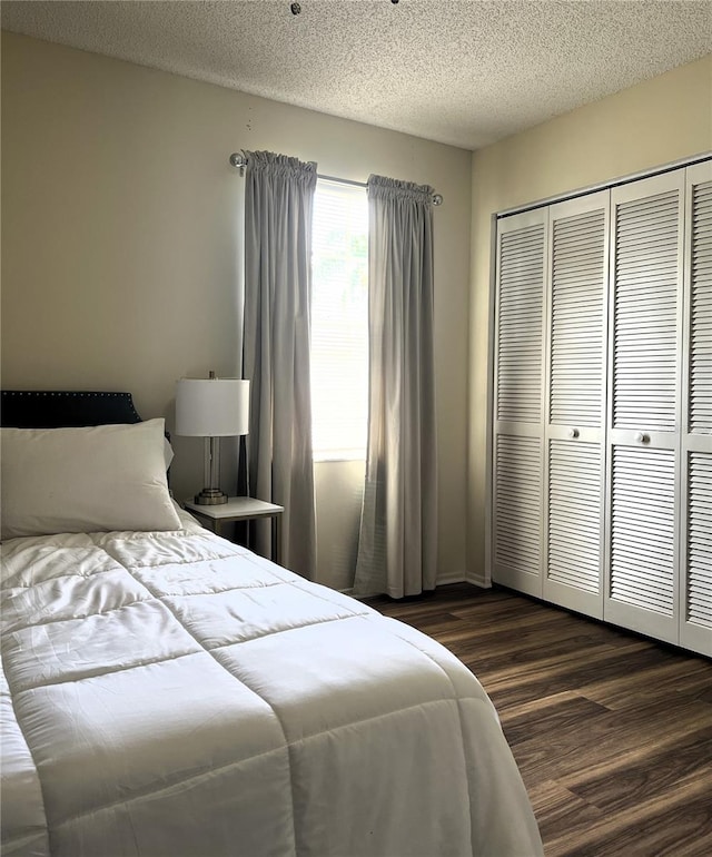 7721 Hillside Ct Unit 203, Hudson, FL 34667 - bedroom with wood finished floors, a closet, and a textured ceiling