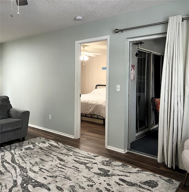 7721 Hillside Ct Unit 203, Hudson, FL 34667 - living area with dark wood-style flooring, a ceiling fan, and a textured ceiling
