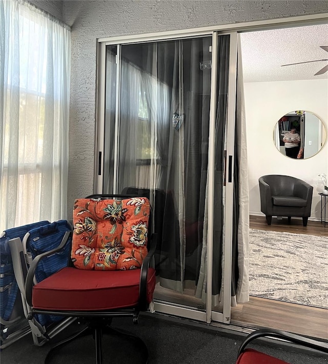 7721 Hillside Ct Unit 203, Hudson, FL 34667 - sitting room featuring wood finished floors, a textured ceiling, and a textured wall