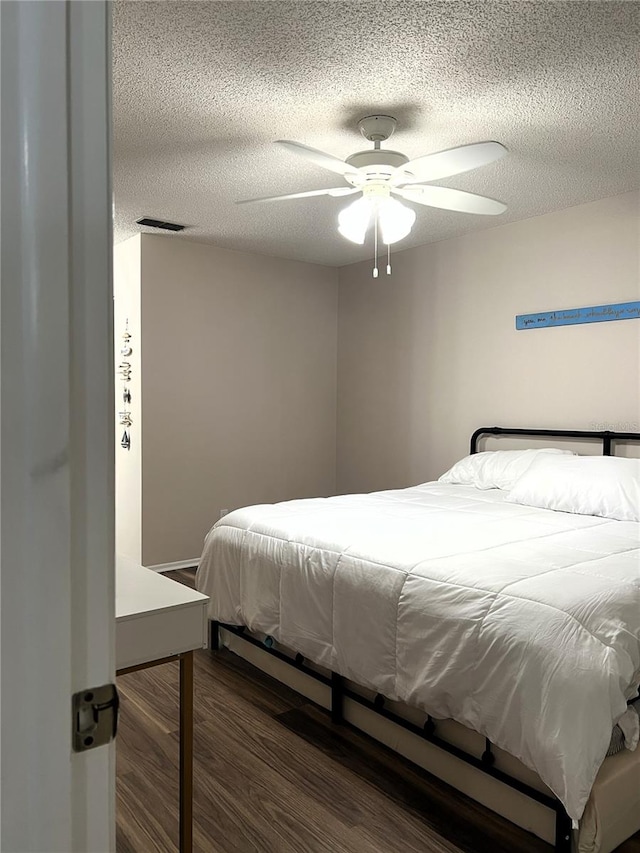 7721 Hillside Ct Unit 203, Hudson, FL 34667 - bedroom featuring wood finished floors, a textured ceiling, and ceiling fan