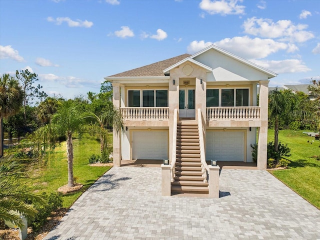 5621 Egrets Pl, New Port Richey, FL 34652 - raised beach house featuring stairs, french doors, decorative driveway, stucco siding, and a front yard