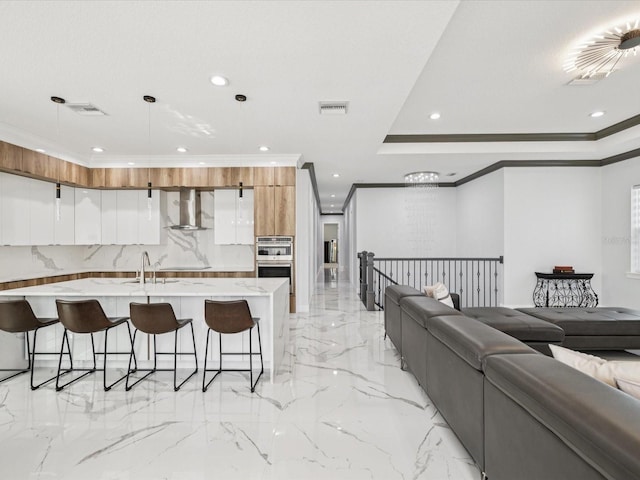 5621 Egrets Pl, New Port Richey, FL 34652 - kitchen featuring modern cabinets, recessed lighting, a breakfast bar, open floor plan, and white cabinetry