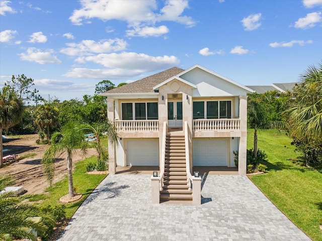 5621 Egrets Pl, New Port Richey, FL 34652 - coastal inspired home with stairway, decorative driveway, stucco siding, french doors, and an attached garage