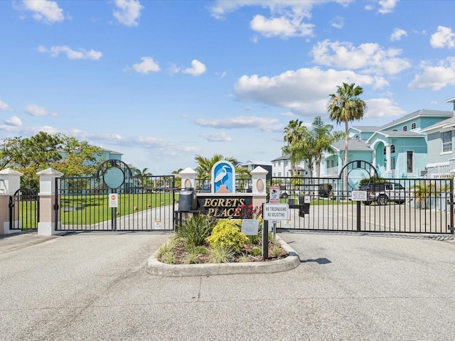 5621 Egrets Pl, New Port Richey, FL 34652 - view of asphalt road with a gate, a gated entry, curbs, and traffic signs