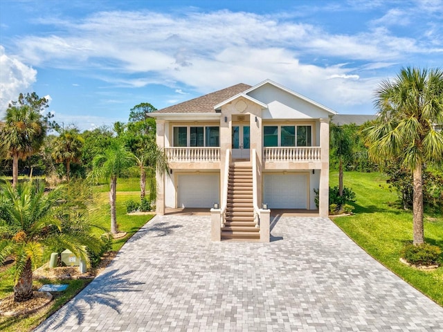 5621 Egrets Pl, New Port Richey, FL 34652 - beach home with stairway, a front yard, a garage, decorative driveway, and stucco siding