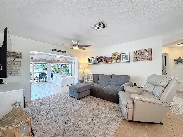 12817 2nd Isle, Hudson, FL 34667 - living room featuring tile patterned floors, ceiling fan, and a textured ceiling