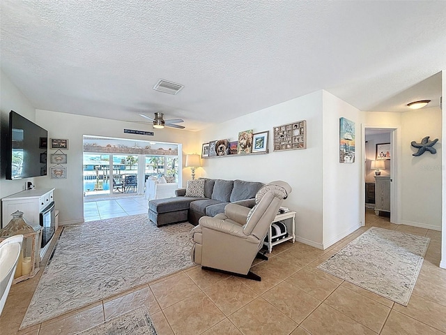 12817 2nd Isle, Hudson, FL 34667 - living room with light tile patterned floors, a ceiling fan, and a textured ceiling