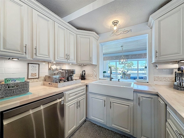 12817 2nd Isle, Hudson, FL 34667 - kitchen with stainless steel dishwasher, tasteful backsplash, light countertops, white cabinetry, and a textured ceiling