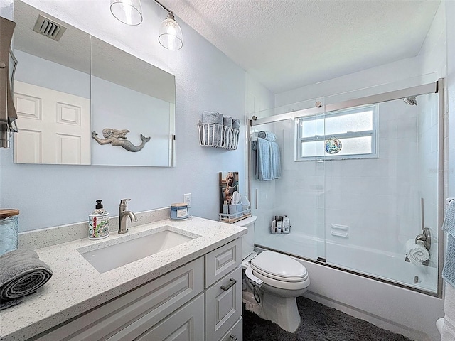 12817 2nd Isle, Hudson, FL 34667 - full bathroom featuring vanity, bath / shower combo with glass door, and a textured ceiling